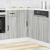 A corner of a modern kitchen with light gray wooden cabinets and a white countertop.