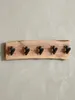 Frontalansicht der Wandgarderobe mit einzigartiger Baumkante aus massivem Akazienholz und fünf robusten, schwarzen Metallhaken, Maße 60 x 17 cm._#sku_BARWL6.358# Produktbild-Vorschau