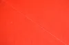 A close-up, abstract view of a red surface with a thin white line running diagonally across it. Produktbild-Vorschau