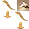 A collage of images showing two bird-shaped table lamps, one on a white background and two on a table with books. Produktbild-Vorschau
