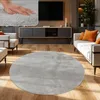 A living room scene with a round rug in the foreground. Produktbild-Vorschau