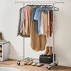 Clothing rack with various garments hanging on it, and shoes and a box on the lower shelf. Podgląd zdjęcia produktu