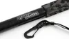 A close-up view of a carbon fiber fishing net handle with a camouflage grip and a black carabiner clip attached. Produktbild-Vorschau