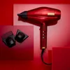 A red Babyliss Pro hair dryer with attachments is displayed against a red background with geometric shapes. Anteprima dell’immagine prodotto
