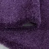 A close-up view of a fluffy, shaggy rug with a high pile, showing the texture and the underside of the rug where it is folded. Anteprima dell’immagine prodotto