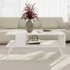 A white coffee table with storage is placed in a living room setting, in front of a sofa. Podgląd zdjęcia produktu