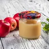 A jar of applesauce with apples on a wooden table. Produktbild-Vorschau