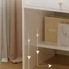 Close-up view of a white vanity table with shopping bags on a shelf. Náhľad obrázku produktu