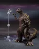 A Godzilla action figure stands on a display base, with a small airplane model on a stand in front of it. Náhled obrázku produktu
