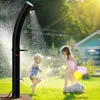Two young children playing in a backyard with a solar shower spraying water. Náhled obrázku produktu