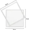 A square frame is placed diagonally over a square white panel, with dimensions indicated by text. Produktbild-Vorschau