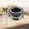 A garbage disposal unit and its sink flange are displayed on a wooden table with a blurred kitchen background. Podgląd zdjęcia produktu
