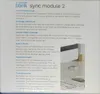 The image shows the packaging of a Blink Sync Module 2, with text describing its features and functions in multiple languages. Podgląd zdjęcia produktu