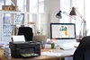 A home office desk with a printer, computer, and office supplies. Produktbild-Vorschau