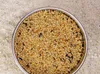 A close-up, top-down view of a metal bowl filled with birdseed. Produktbild-Vorschau