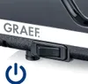 A close-up of a black electrical appliance with the brand name 'GRAEF' visible on a white stripe. A black power switch and a blue power symbol are also visible. Podgląd zdjęcia produktu