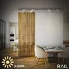 A modern interior space with a dining table and chairs, featuring a wooden slatted room divider and track lighting. Náhľad obrázku produktu