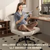 A woman is sitting on a white office chair with her legs crossed, reading a magazine. The chair is in a home office setting with a desk and shelves in the background. Produktbild-Vorschau