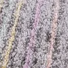 A close-up view of a carpet with pastel-colored stripes. Produktbild-Vorschau