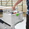 A person's hand is shown pulling a Festool Systainer³ toolbox out of a sliding drawer on a workbench. Anteprima dell’immagine prodotto