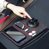 Schwarze rutschfeste Auto-Armaturenbrett-Matte mit rotem Rand, die ein Smartphone, einen Autoschlüssel, einen USB-Stick und Münzen hält, mit einer Hand, die den Handyhalter einstellt Náhľad obrázku produktu