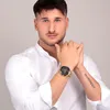 A man wearing a white shirt and a gold watch. Produktbild-Vorschau