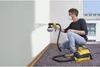 A man is painting a wall with a paint spray system. Anteprima dell’immagine prodotto