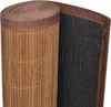 A rolled-up bamboo rug with a brown fabric trim and a black backing. Produktbild-Vorschau
