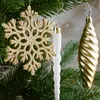 Close-up of Christmas tree ornaments hanging from branches. Náhľad obrázku produktu