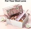 A pink USB hub is presented as a gift in a decorative box, surrounded by ribbons and flowers. Produktbild-Vorschau