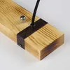 Close-up of a wooden beam with a metal bracket and a black cable attached. Anteprima dell’immagine prodotto