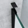 A close-up view of a black metal frame and a piece of glass, likely part of a shower enclosure, against a textured gray wall. Produktbild-Vorschau