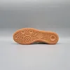The sole of a tan Adidas Handball Spezial shoe is shown against a plain gray background. Voir les images du produit