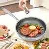 A person is seasoning food in a frying pan, with other food items and a cake on the table. Produktbild-Vorschau