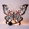 A decorative solar-powered butterfly light with colorful jewel accents. Produktbild-Vorschau