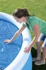 A woman is placing a solar cover on an inflatable pool. Produktbild-Vorschau