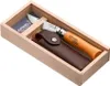 A wooden box containing an Opinel pocket knife and a leather sheath. Anteprima dell’immagine prodotto