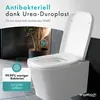 A modern bathroom setting with a white toilet and a plant in the background. Produktbild-Vorschau