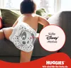 A baby wearing a diaper with a Disney character print is sitting on a sofa. There is a marketing overlay with text and a brand logo. Náhľad obrázku produktu