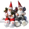 Two Santa Claus figurines sitting on a white surface. Náhľad obrázku produktu