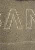 A close-up view of embroidered text on a textured fabric. Produktbild-Vorschau