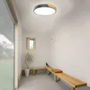 A modern hallway with a wooden bench and a plant, illuminated by a ceiling light. Voir les images du produit