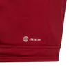 A close-up view of a red fabric with a white logo and text. Voir les images du produit