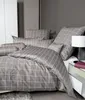 A neatly made bed with a grey and white checkered duvet cover and pillows. Produktbild-Vorschau