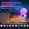 A child sleeping in bed with a night light shaped like an astronaut. Produktbild-Vorschau