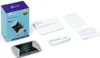 A product shot of a TP-LINK M7450 mobile hotspot and its packaging, along with included accessories and documentation. Produktbild-Vorschau