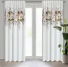 Two white curtains with a floral pattern at the top, hanging in front of a window. Podgląd zdjęcia produktu