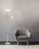 A floor lamp and an armchair are shown against a textured gray wall. Anteprima dell’immagine prodotto