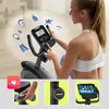A woman using a stationary bike, with inset images showing product details and features. Produktbild-Vorschau