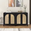 A black sideboard with rattan doors is displayed in a room setting, with artwork on the wall and a rug on the floor. Podgląd zdjęcia produktu